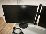 a computer monitor and speakers sitting on a table