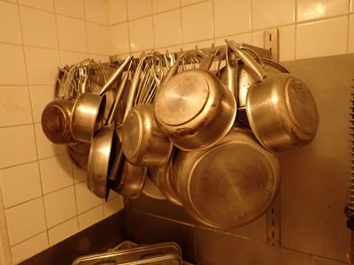 des casseroles et des poêles accrochées au mur d'une cuisine