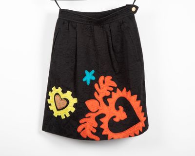 une jupe noire ornée de fleurs orange et bleues