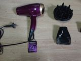 a hair dryer, comb, and other hair accessories on a table