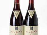 deux bouteilles de vin rouge posées l'une à côté de l'autre sur une surface blanche