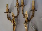pair of antique brass wall sconces with figurines and candle holders