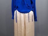 une photo d'un mannequin portant une chemise bleue et un pantalon beige