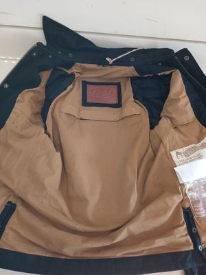 a jacket that is sitting on the floor next to a bag