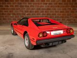 a red sports car parked in front of a brick wall