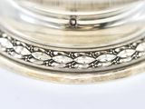 a close up of a silver plate on a white surface