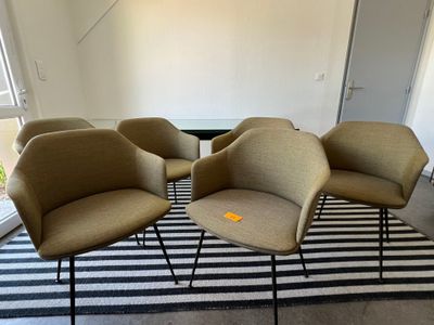 quatre chaises aux pieds noirs et un tapis rayé noir et blanc