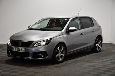 La voiture argentée est garée sur le sol à damier de la pièce.