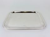 a silver tray with a handle on a white surface