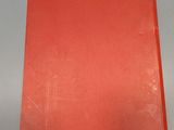 an orange book sitting on top of a table next to a white wall