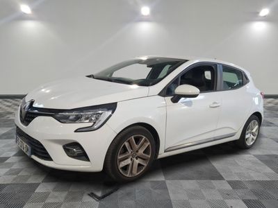 une voiture blanche est garée dans une grande pièce au sol en damier