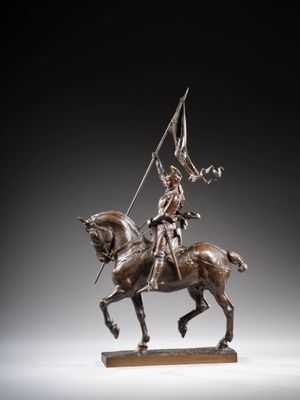 statue représentant un homme à cheval, tenant un drapeau, posée sur un socle en bois