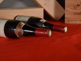 two bottles of wine sitting on a red cloth