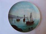 une assiette ornée d'une peinture représentant des bateaux sur l'eau