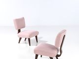 a pair of pink chairs sitting next to each other on a white surface
