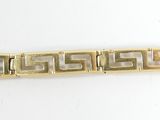 an image of a gold bracelet on a white surface