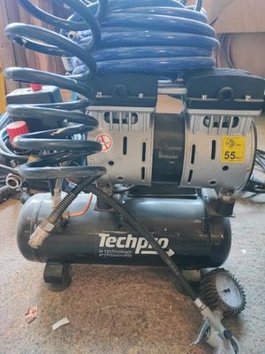un petit compresseur d'air posé sur une pile d'outils