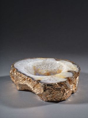 une photo d'un bol doré et blanc posé sur une table