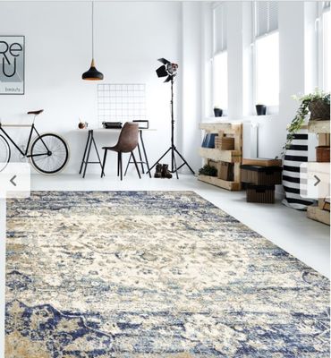 un grand tapis dans une pièce où se trouve un vélo posé par terre