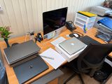 un bureau sur lequel se trouvent un ordinateur portable, un écran, un clavier, une souris et un téléphone