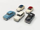 several toy cars are lined up in a row on a white surface