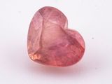 a close up of a pink heart shaped stone on a white surface