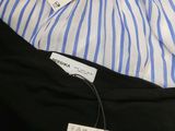 the shirt is blue and white striped with a tag on it