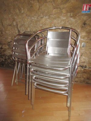 quatre chaises et une table devant un mur de pierre