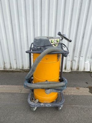 a yellow dust collector with a hose on a cart