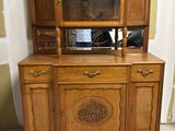 une vieille armoire en bois surmontée d'un miroir