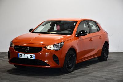 Une voiture orange est garée dans une pièce dont le sol est en damier.