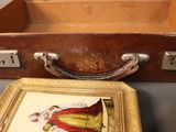a picture of a picture of a woman in a dress in an old suitcase