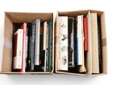 many books in a cardboard box on a white surface