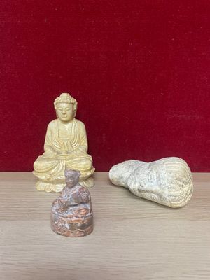 two small statues sitting on a table next to each other
