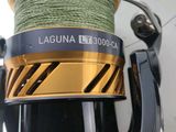 the fishing reel is next to a spool of thread and a spool of thread