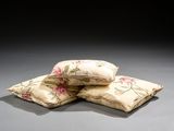 three pillows sitting on top of each other on a table