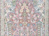 an antique persian rug with a floral design on a pink ground