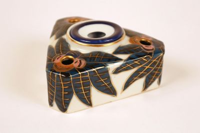 a small blue and white vase sitting on a white surface
