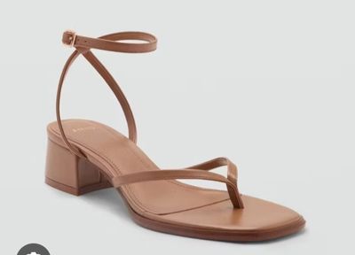a pair of women ' s tan leather sandals with ankle straps