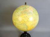 un globe jaune et noir posé sur un socle noir