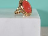 une image représentant une bague en or ornée d'un corail au centre