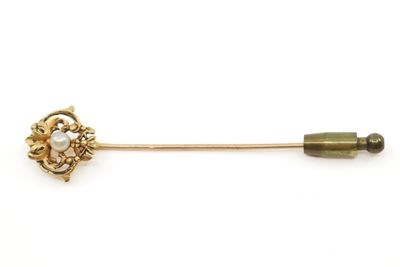 un gros plan d'une broche en or ornée de perles
