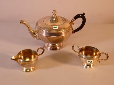 deux théières en argent et deux tasses en argent posées sur une table