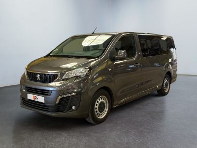 La petite camionnette est garée dans une grande pièce au sol gris.