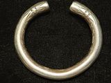 gros plan d'un bracelet en argent sur une surface noire