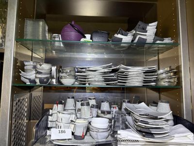 many plates and bowls on the shelves in the kitchen