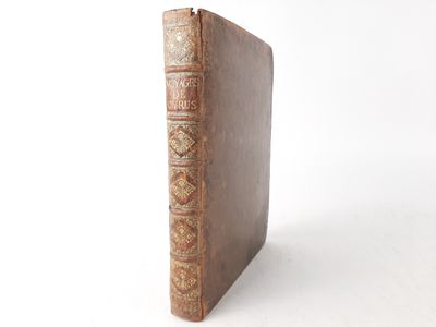 an old book sitting on top of a white table next to a white wall