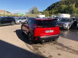 a red car parked in a parking lot next to other cars