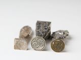several different types of silver and gold coins on a white surface