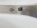 a silver spoon and a silver spoon on a white table